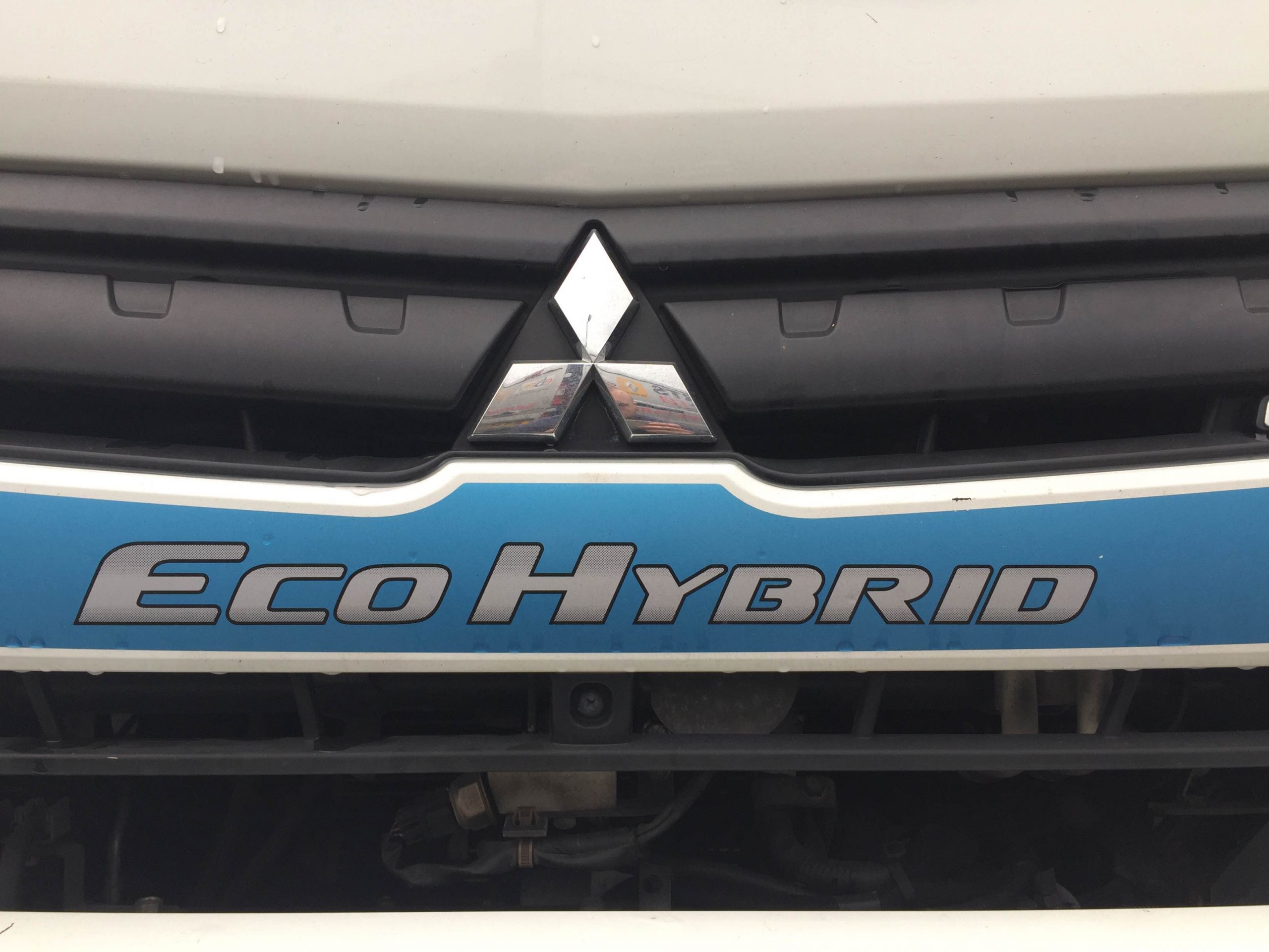 Close-up of a Mitsubishi truck grille with an Eco Hybrid badge