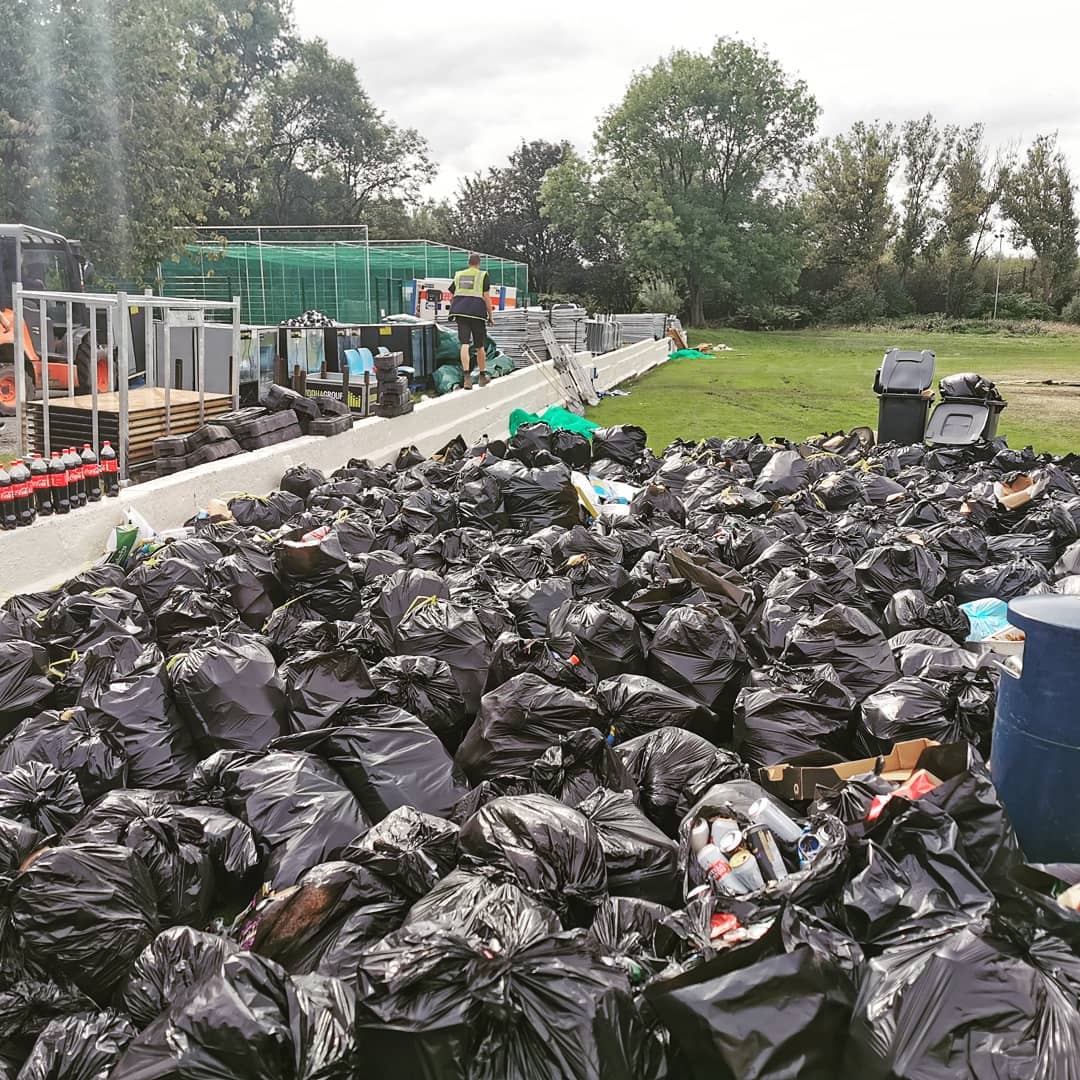 Hundreds of full black bin bags gathered on a festival site