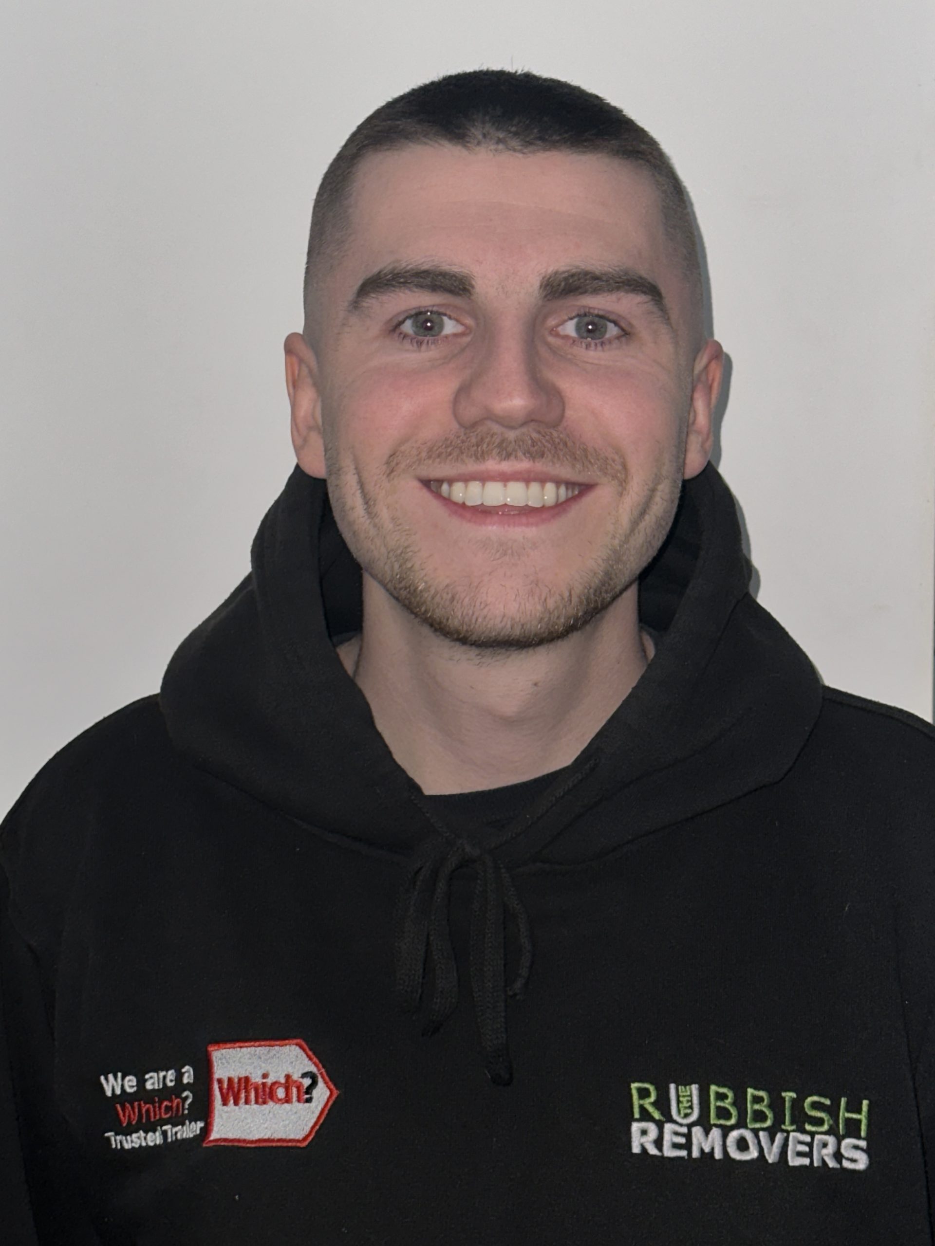 Headshot of a smiling team member in a black Rubbish Removers hoodie