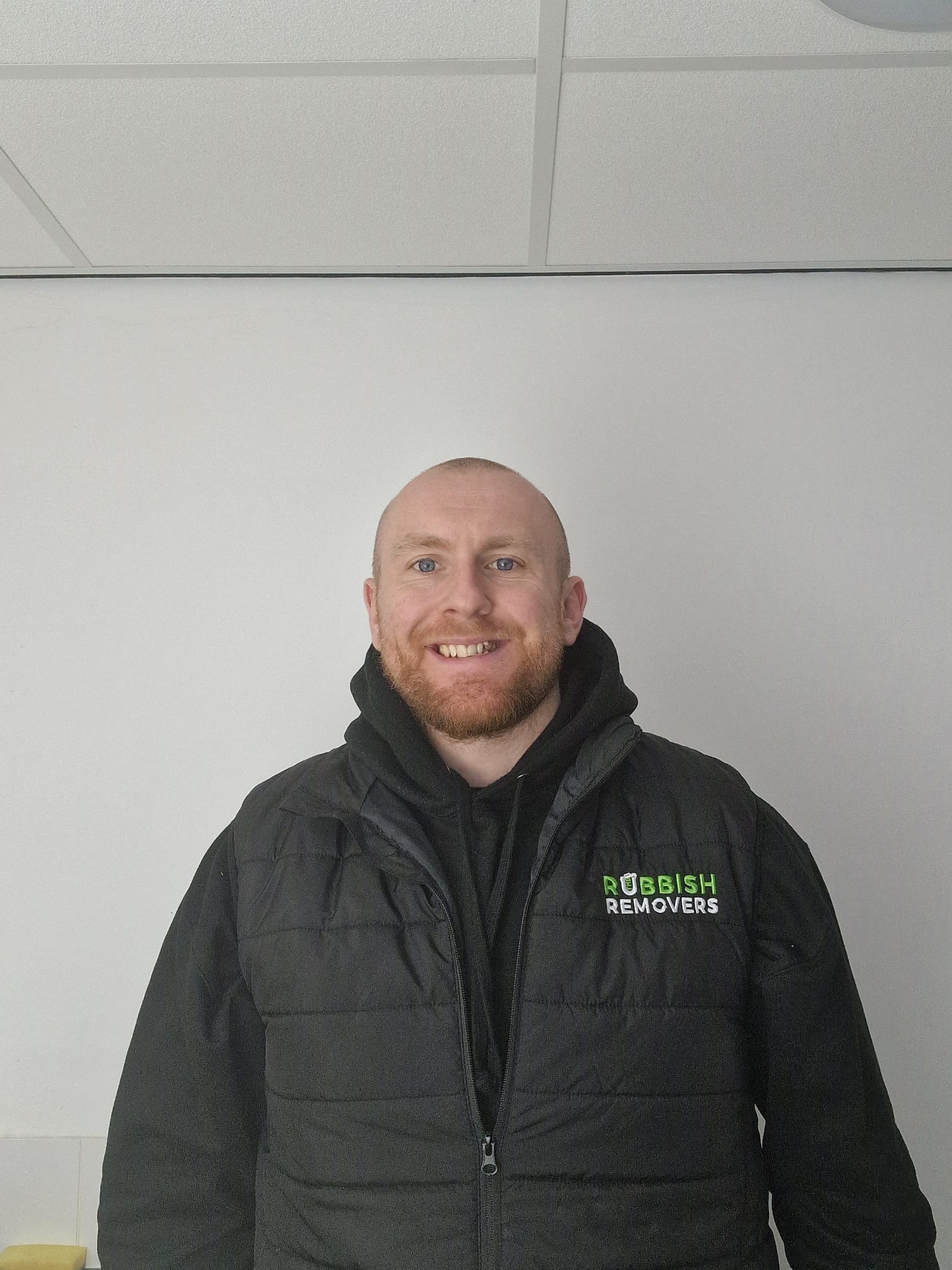 Headshot of a smiling team member in a black Rubbish Removers jacket