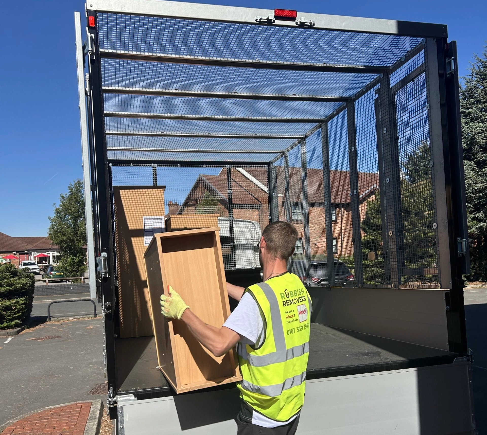 Licensed team member loading wooden office furniture onto the van
