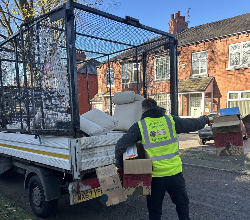 Cardboard and furniture waste being loaded onto a 14 yard caged tipper, by our Manchester Waste Removal Team.