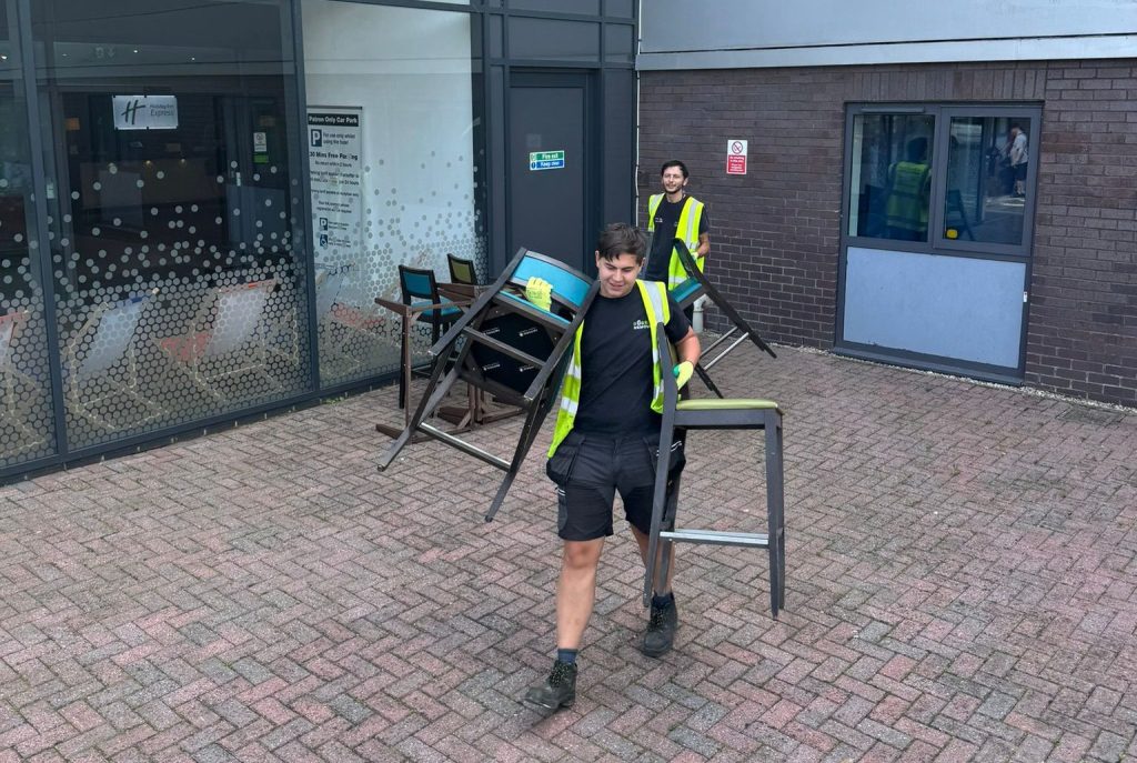 Image showing 2 members of staff removing chairs from a Bury Trade Waste collection.