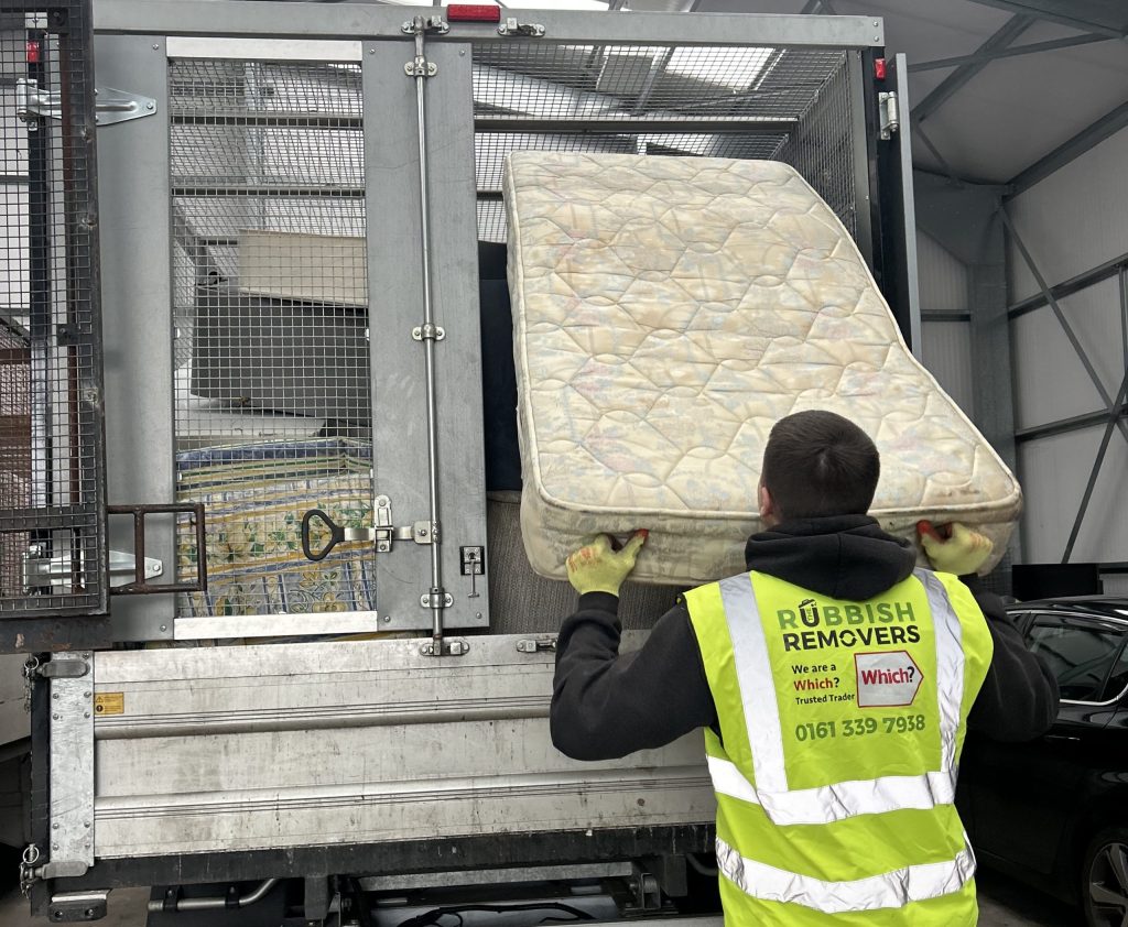 Picture showing staff member loading a mattress onto the vehicle.