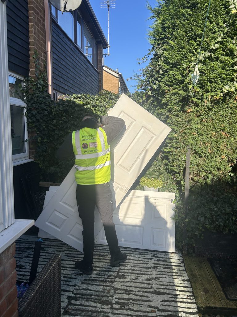 One of our team members removing old wooden doors from a house renovation.