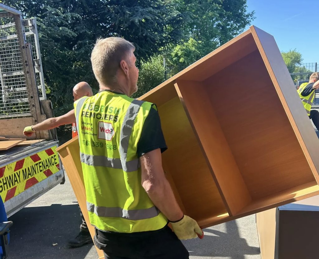 A picture of a Rubbish Removers worker loading a shelving unit from an office onto a 14-yard cage tipper van.