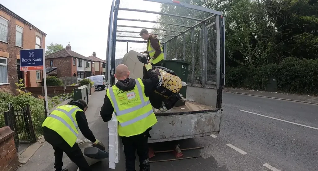 Image showing staff loading a sofa onto our vehicle ready for disposal.