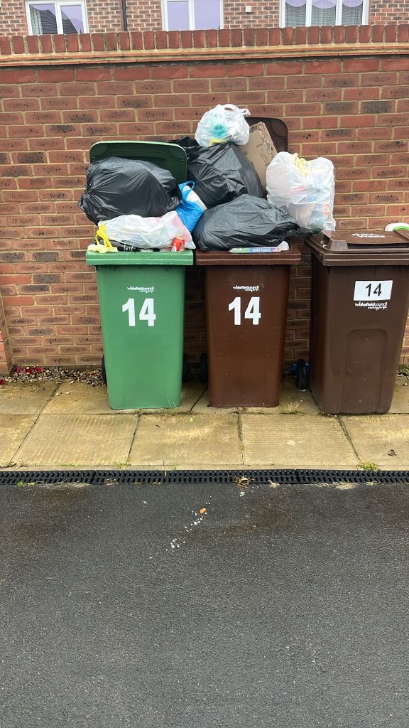Customers bins overflowing with bin bags.