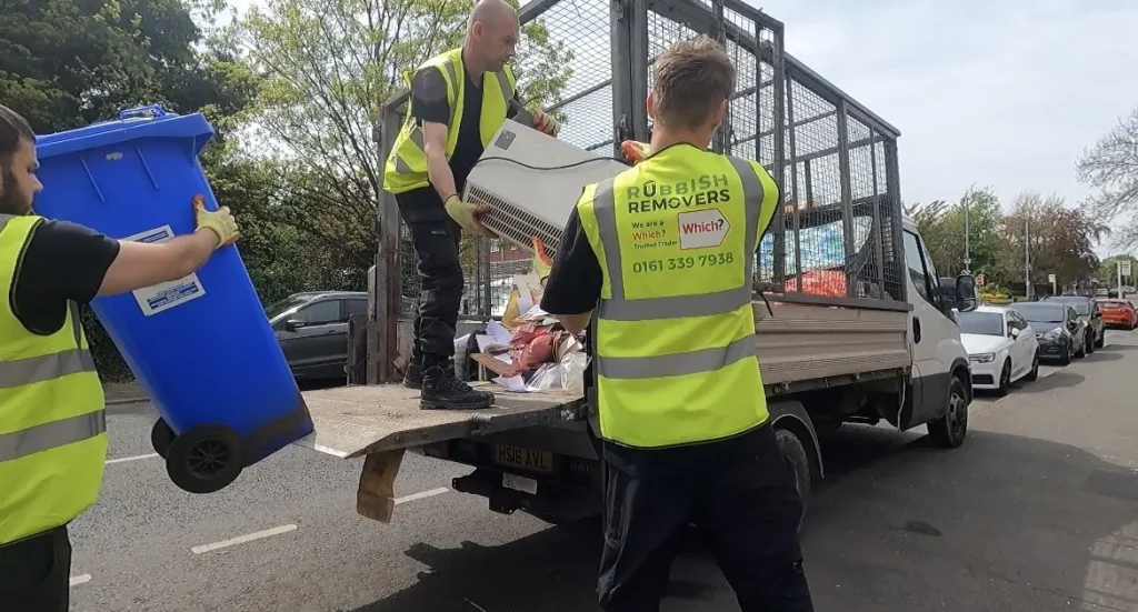 Image showing staff loading a microwave onto a vehicle ready for disposal.