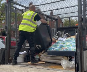 Image of member of staff emptying bin contents onto the vehicle ready for disposal.