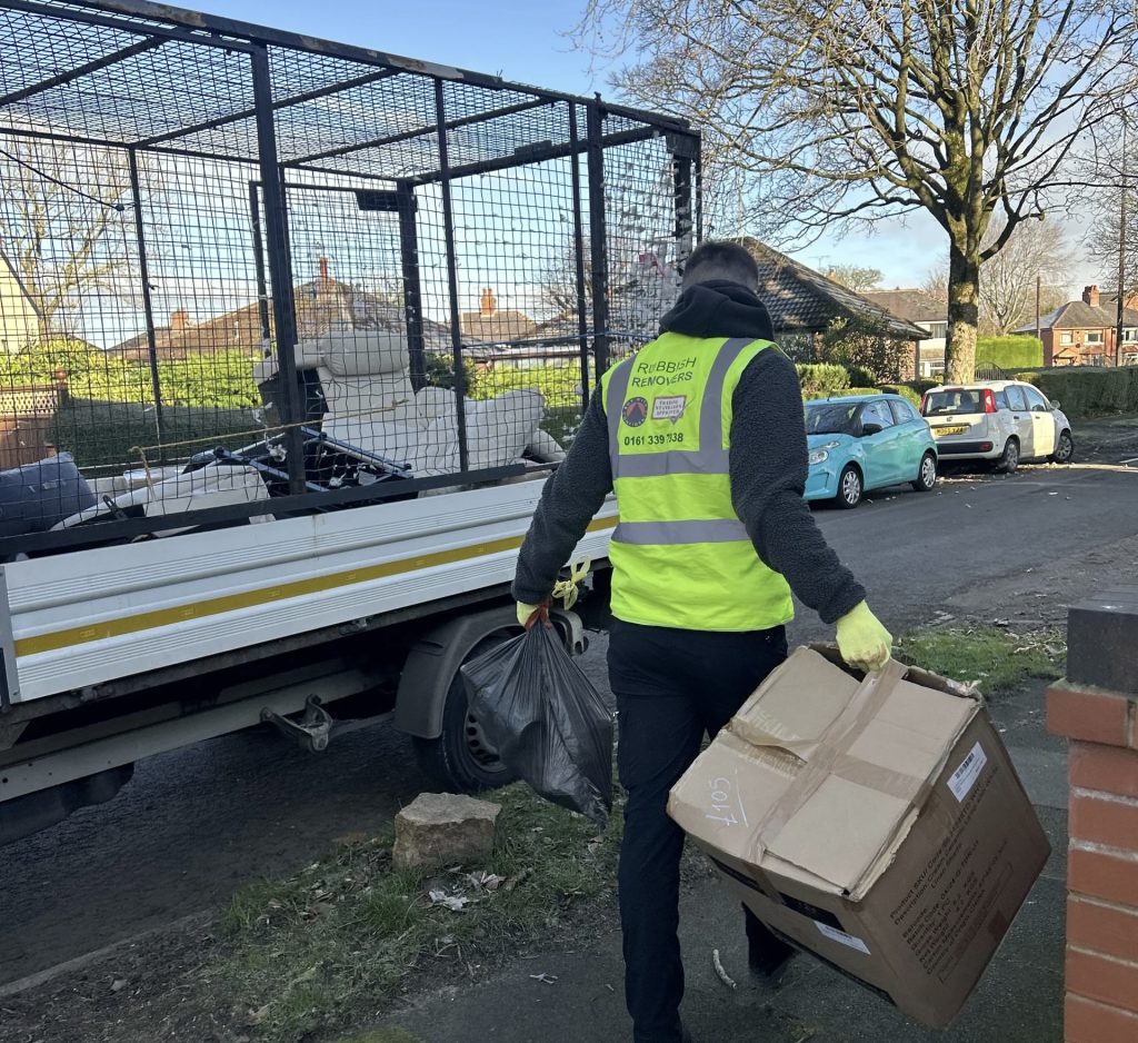 Image of team member removing black bags from a property.