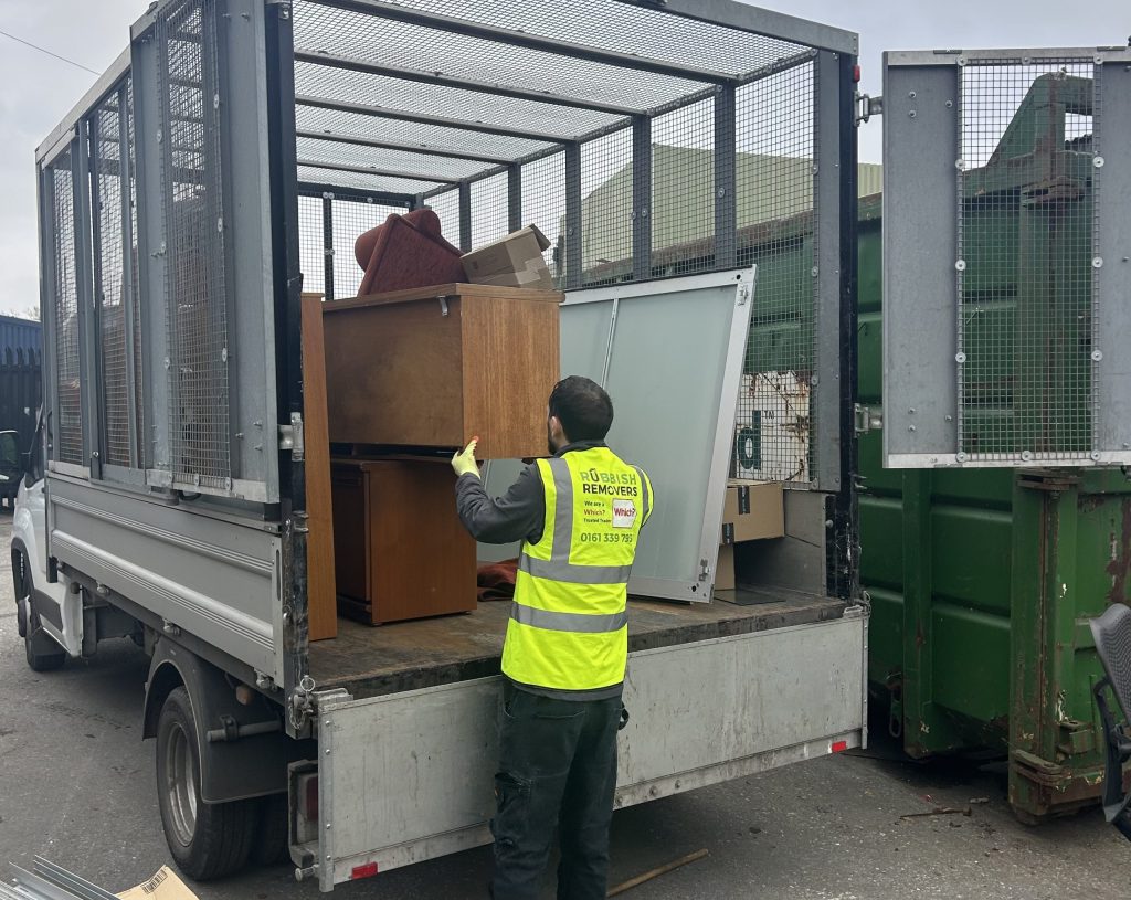 Office furniture being loaded onto the van during a clearance