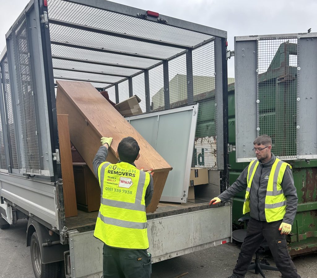 Two man team loading large office furniture onto the van