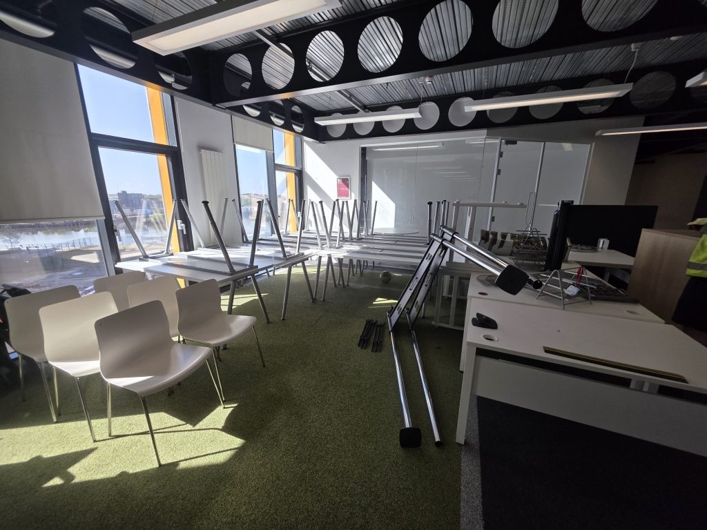 desks chairs and pedestals ready for removal in MediaCity office