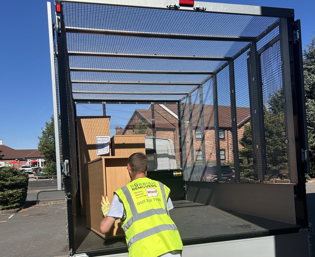 Staff member loading large bulky shelving onto the vehicle.
