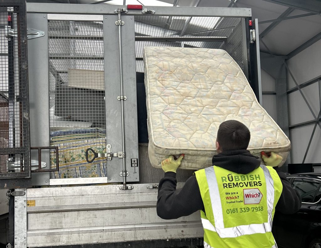 A picture of a Rubbish Removers worker loading a mattress onto a 14-yard cage tipper van.