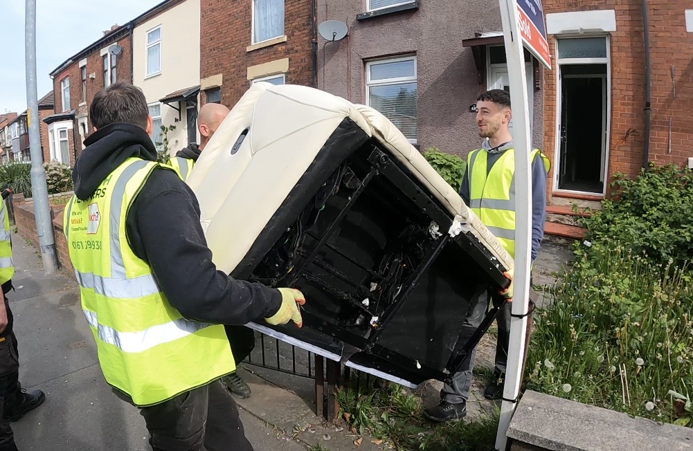 A trusted team removing a bulky sofa from a customers property