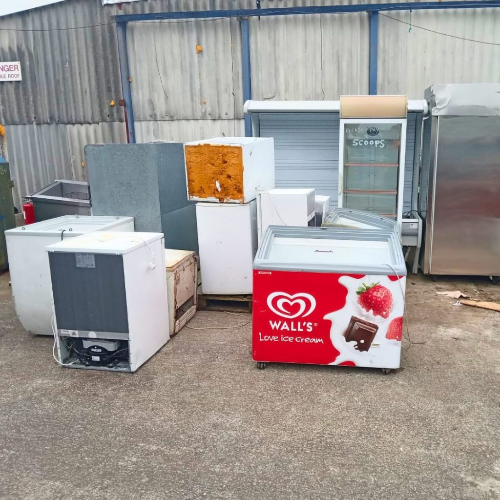 A collection of old and broken commercial fridges and freezers