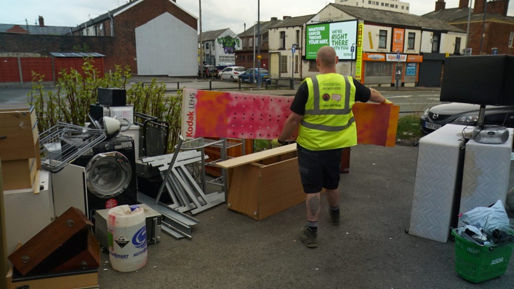 Staff member clearing items from a shop rip-out.