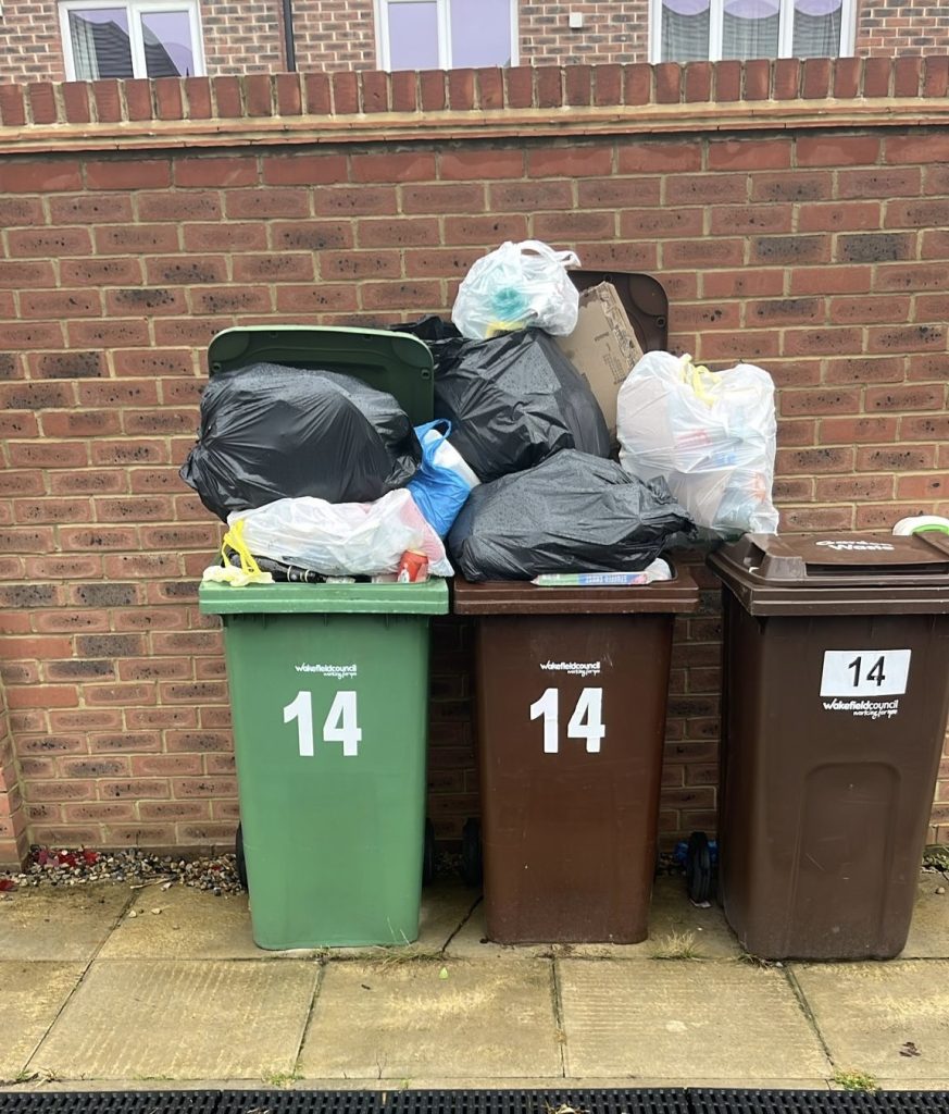 A picture of some overflowing domestic whellie bins that the Rubbish Removers emptied.